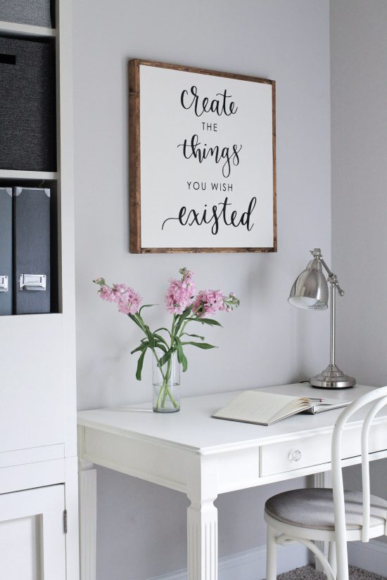 DIY wooden sign above desk on office wall