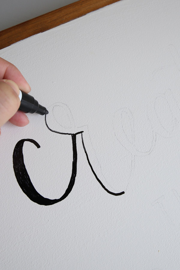 using a paint marker to trace lettering on sign for how to print on wood sign