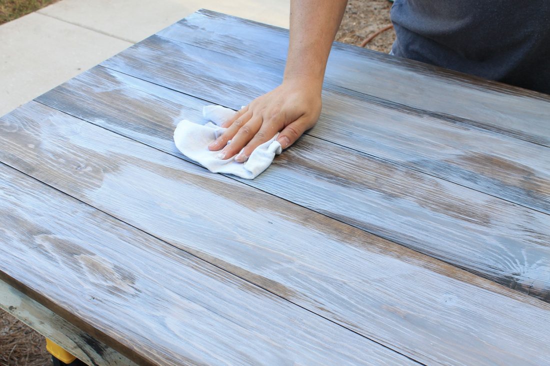 How to create a weathered wood gray finish using a rag to rub in whitewash paint mixture over stain on wood table