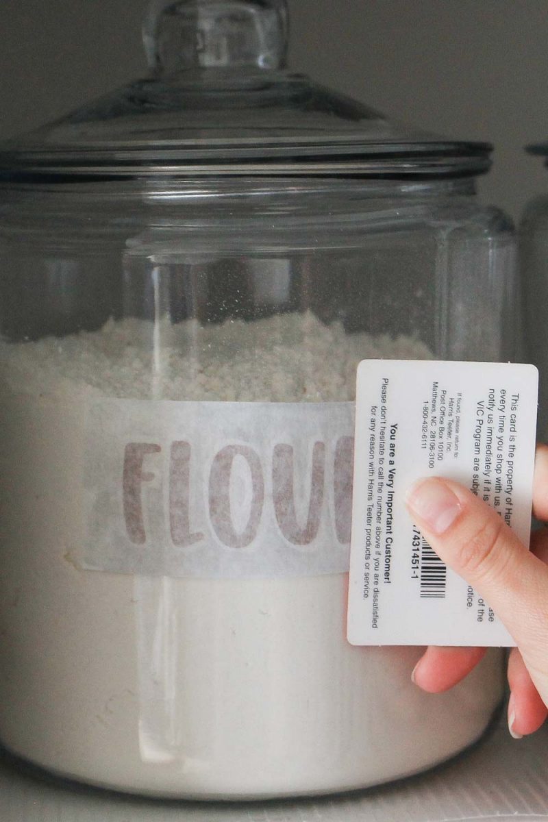 applying vinyl DIY pantry label decal to flour jar with card