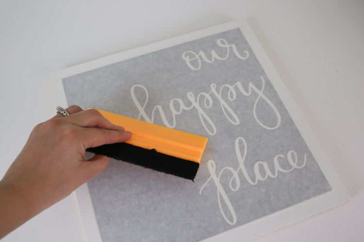 Remove bubbles from transfer tape over vinyl with a squeegee