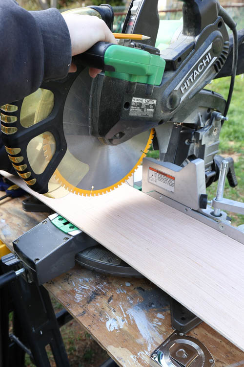 A miter saw cutting shiplap boards to size for shiplap ceiling installation