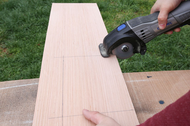 A dremel cutting an opening out of shiplap board for ceiling vent 