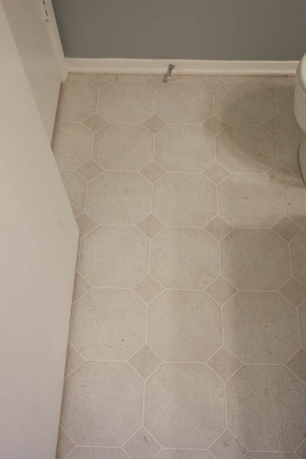 old vinyl tile being replaced in DIY bathroom renovation