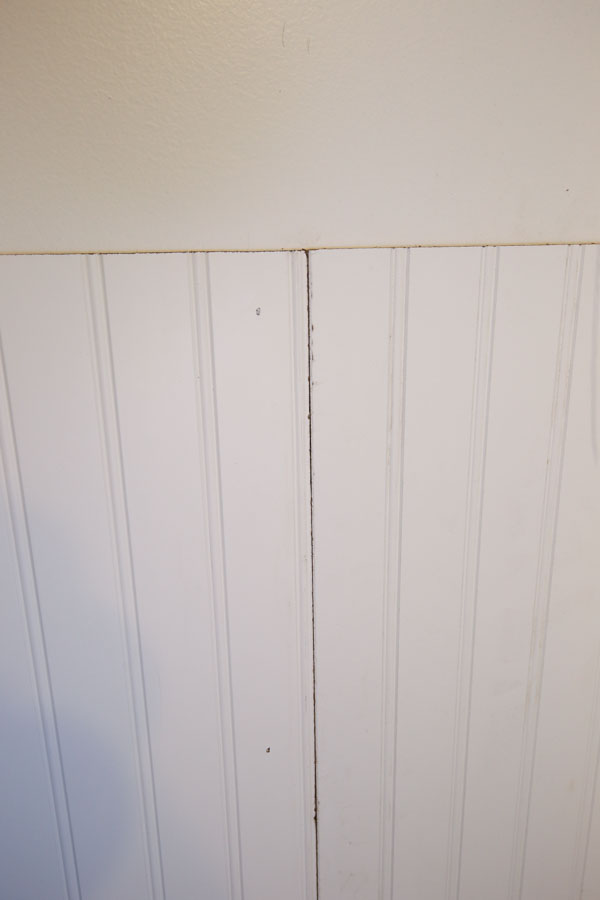 Two beadboard panels being installed on bathroom wall
