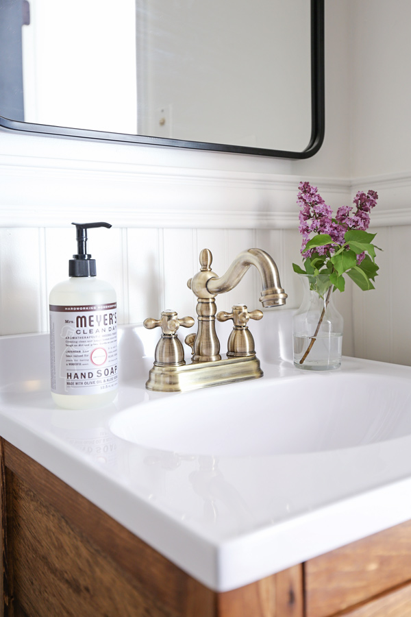 Antique brass bathroom faucet, Mrs. Meyer's Hand Soap, and Lilacs on bathroom vanity