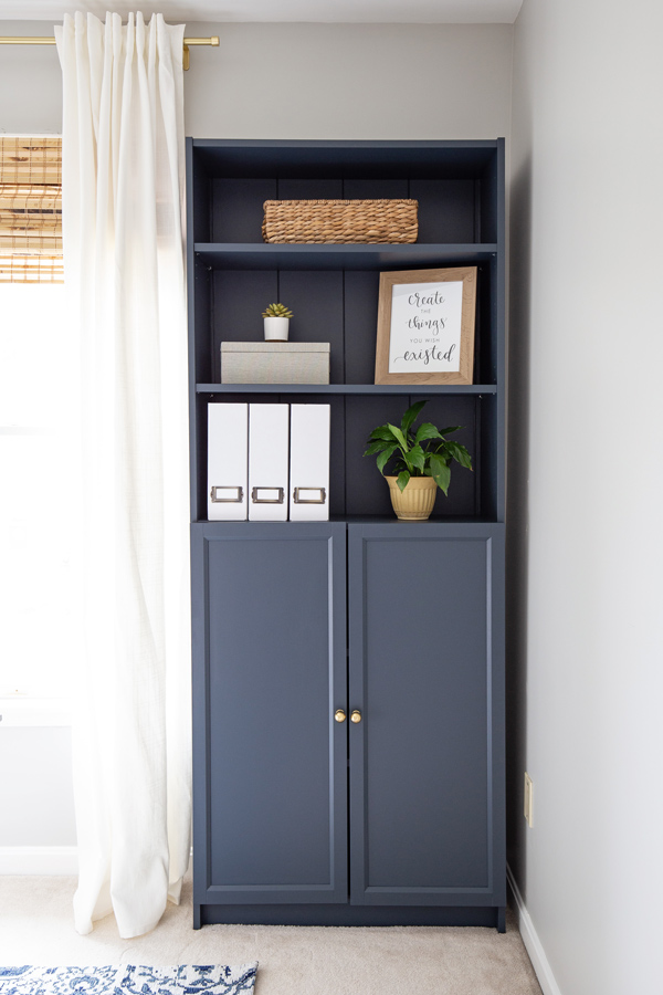 Navy bookcase with styled shelves and decor in a home office