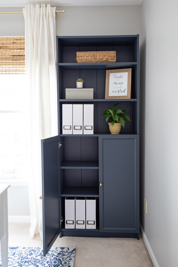Navy bookcase with styled shelves and decor in a home office