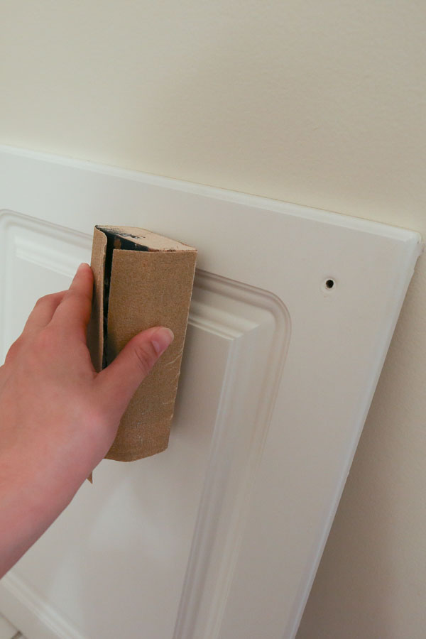 hand sanding bathroom vanity doors before painting