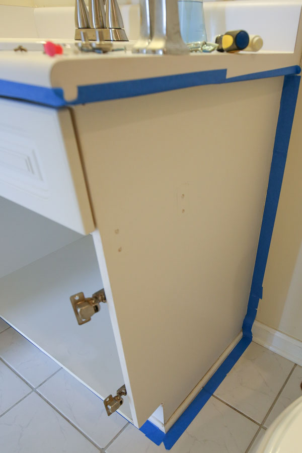 using painters tape to tape off walls and counters before painting bathroom vanity