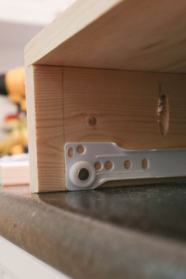 Lining up drawer slide on interior of makeup vanity