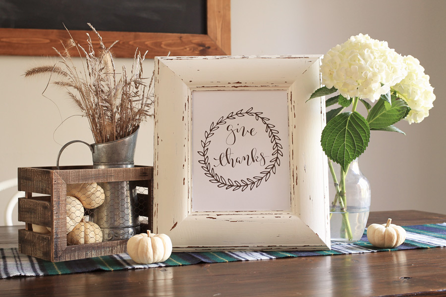 Give Thanks Free Thanksgiving Printable in a picture frame with a pitcher of cotton and greenery