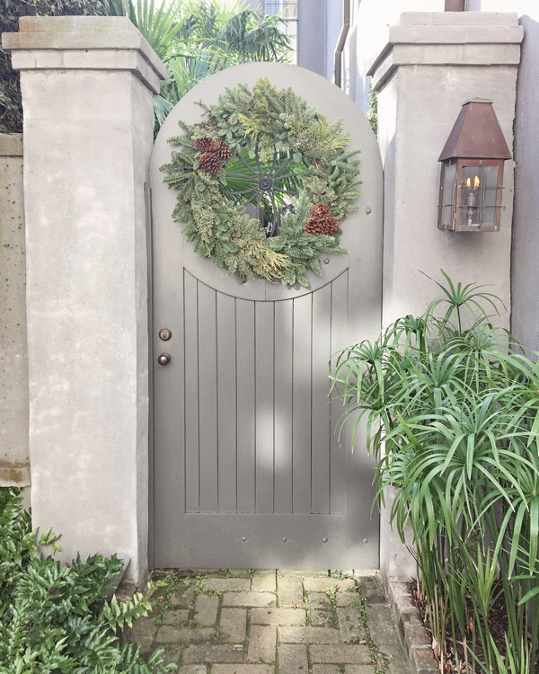 Christmas wreath with pinecones on grey fence door in Charleston for Christmas decor