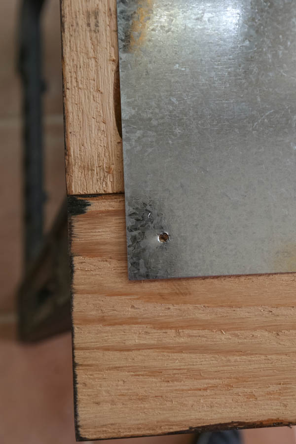 Attaching sheet metal to wood frame by first drilling a hole