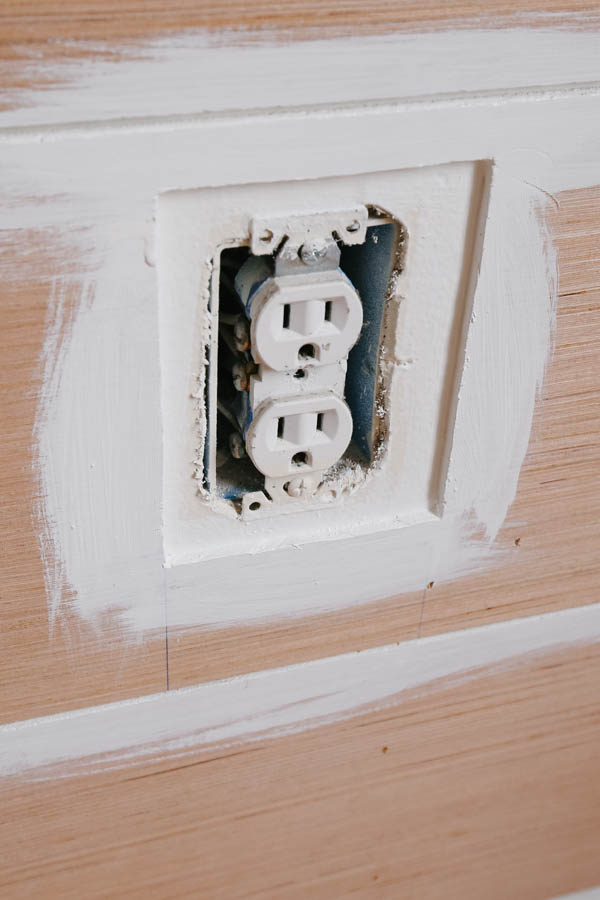 Shiplap boards painted around wall outlet opening