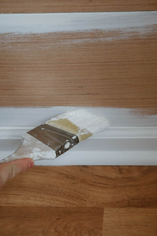 Cut in shiplap wall edges with paint brush