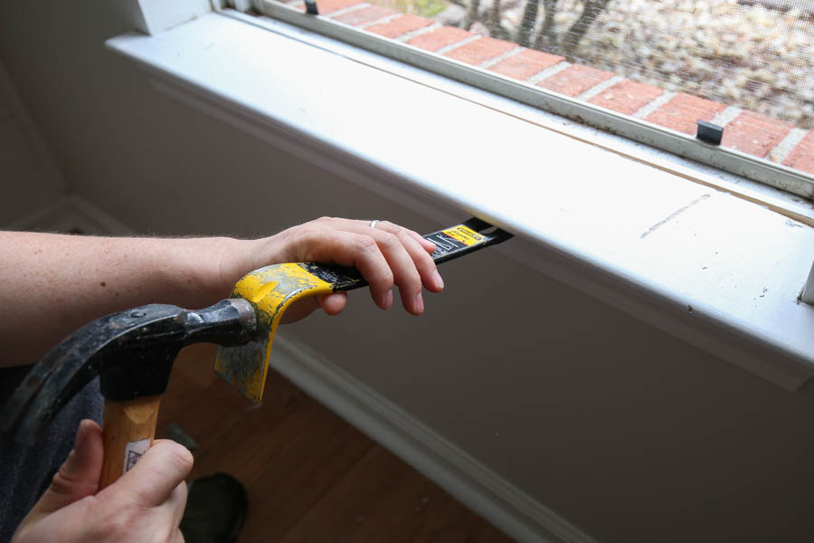 Remove old window sill with hammer and prybar