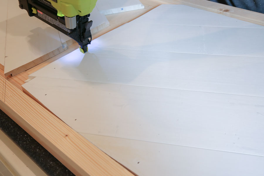 installing shiplap boards with brad nailer for barn door entertainment center DIY
