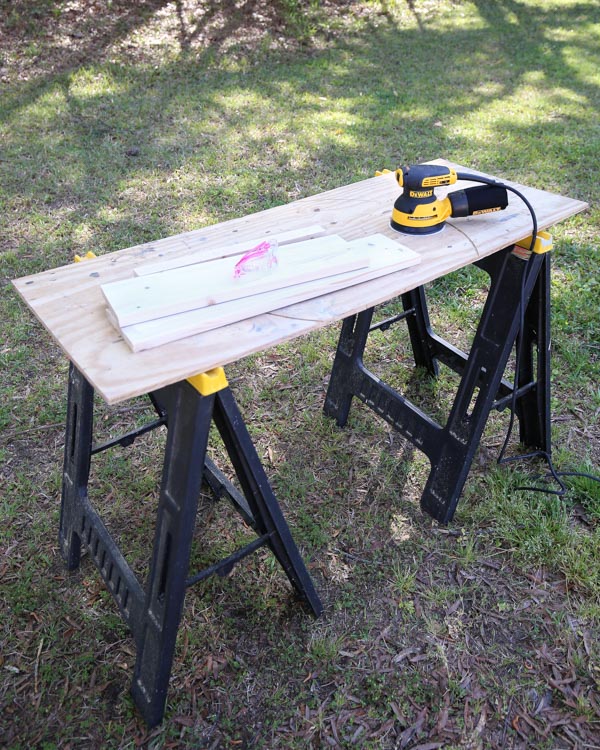 sawhorses wtih plywood set up as a work station for sanding wood