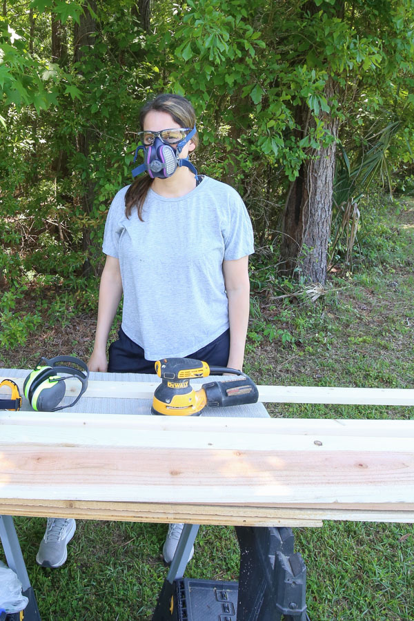 DIYer wearing saftey glasses and sanding mask for personal protective equipment for sanding wood