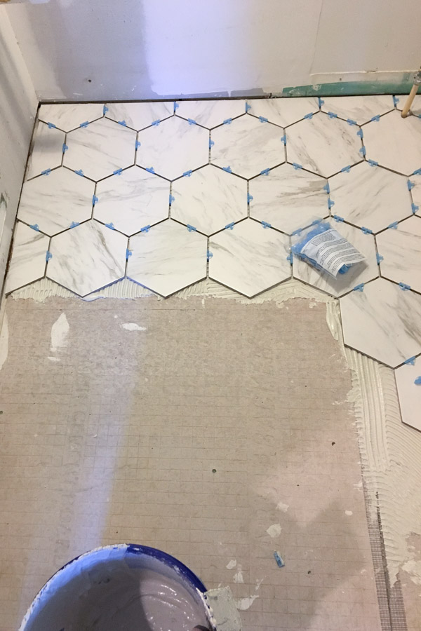 installing the porcelain tile that looks like marble in our master bathroom