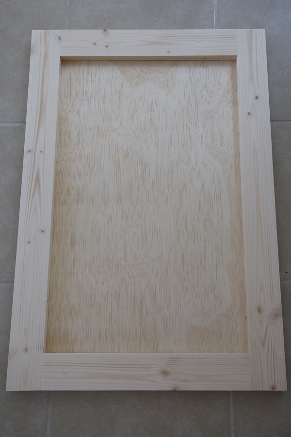 Attach a piece of 1/4" plywood the back of the door frame with screws