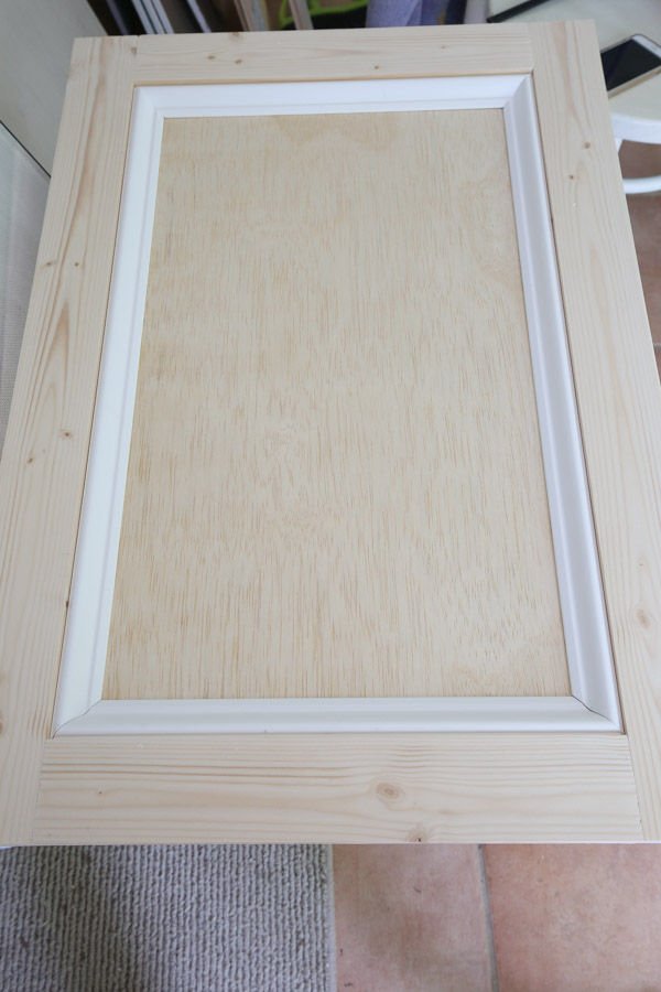 Add base cap molding to the front interior of the cabinet door frame with brad nails