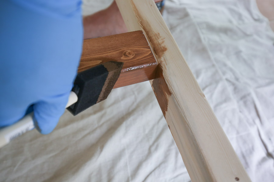 using a foam brush to apply stain to corners of wood project