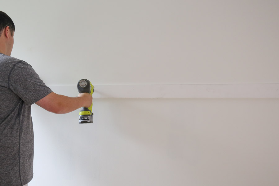 attaching middle board to wall with brad nailer for board and batten wainscoating