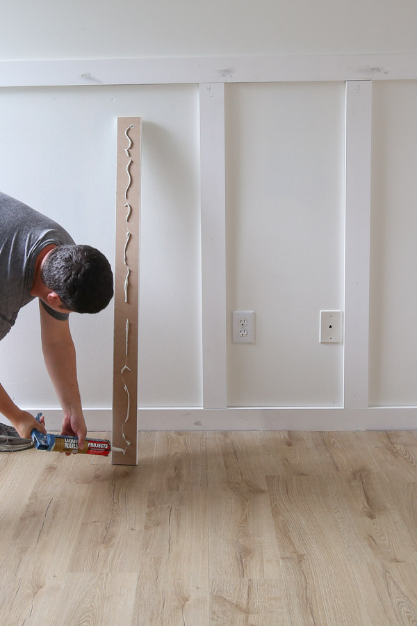 using Liquid nails construction adhesive to attach batten boards to wall for DIY board and batten wall