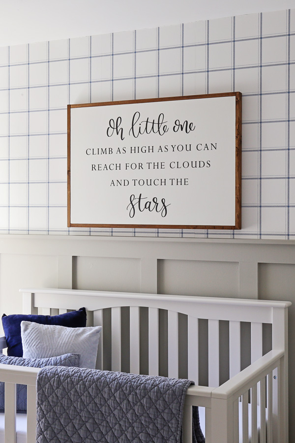 over the crib decor with wood sign over the crib and blue and white wallpaper and gray board and batten