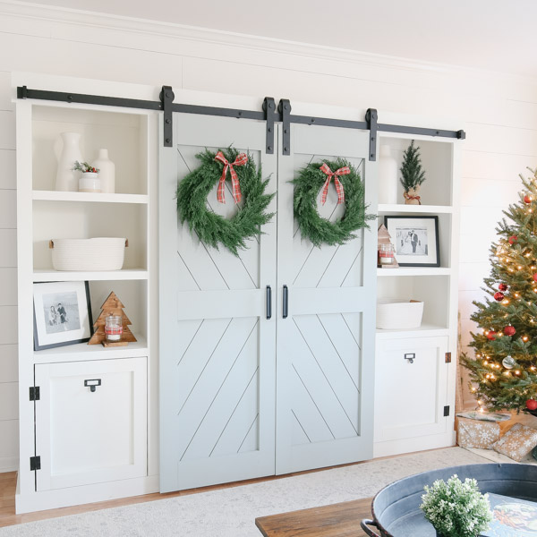 Christmas decor and Christmas wreaths on double barn door entertainment center