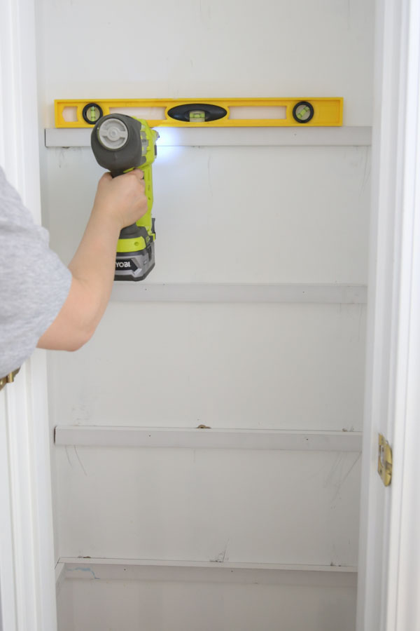 attach pantry shelf support to wall with level and brad nailer first