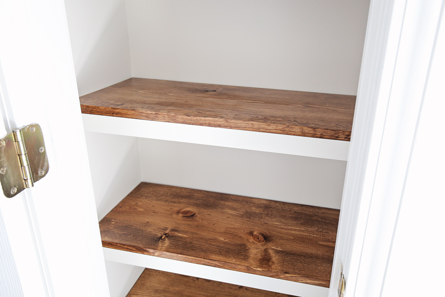 up close photo of DIY Pantry Shelves with stained wood shelves