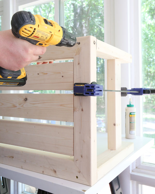 Attach table legs to the table top with wood glue and deck screws