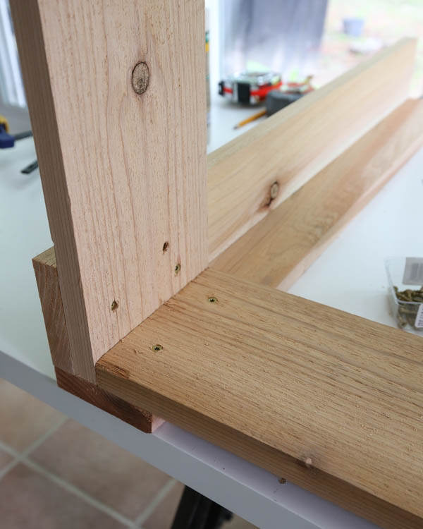 Attach planter box to wood leg with screws