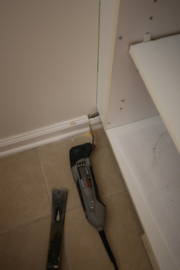 using a Dremel tool to cut adjacent wall baseboard