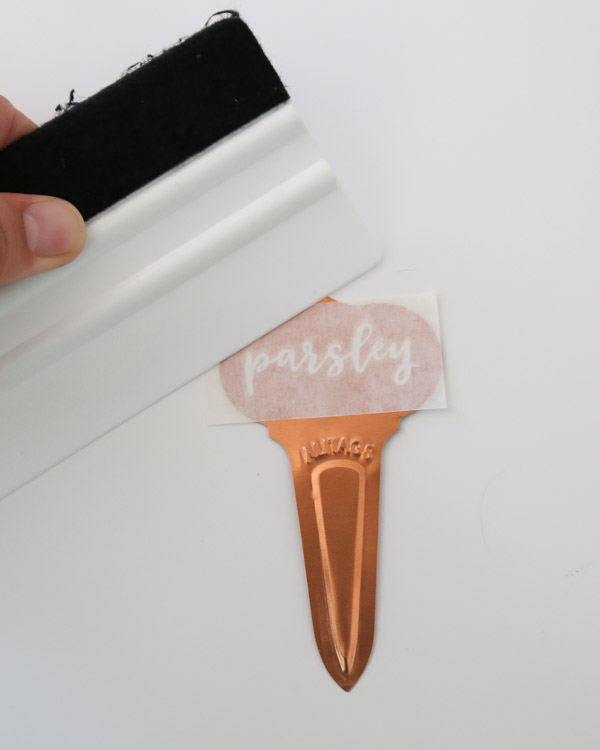 Apply DIY plant label to garden marker and peel back transfer tape