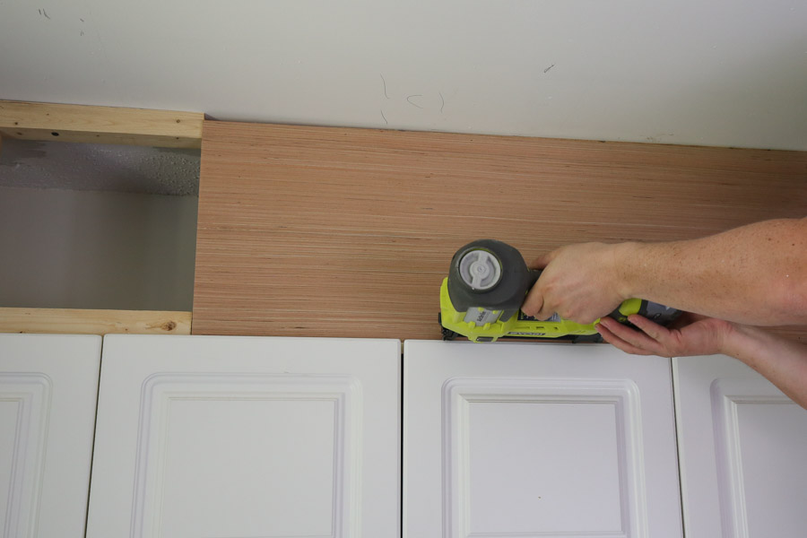 attach plywood to 2x2s to close space above cabinets