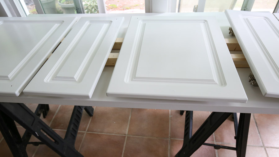 setup for painting cabinets using sawhorses and wood