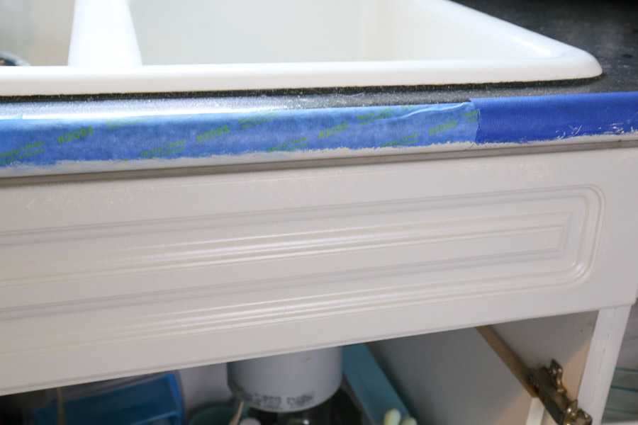 painter's tape along countertop bottom and edge to protect counters from paint