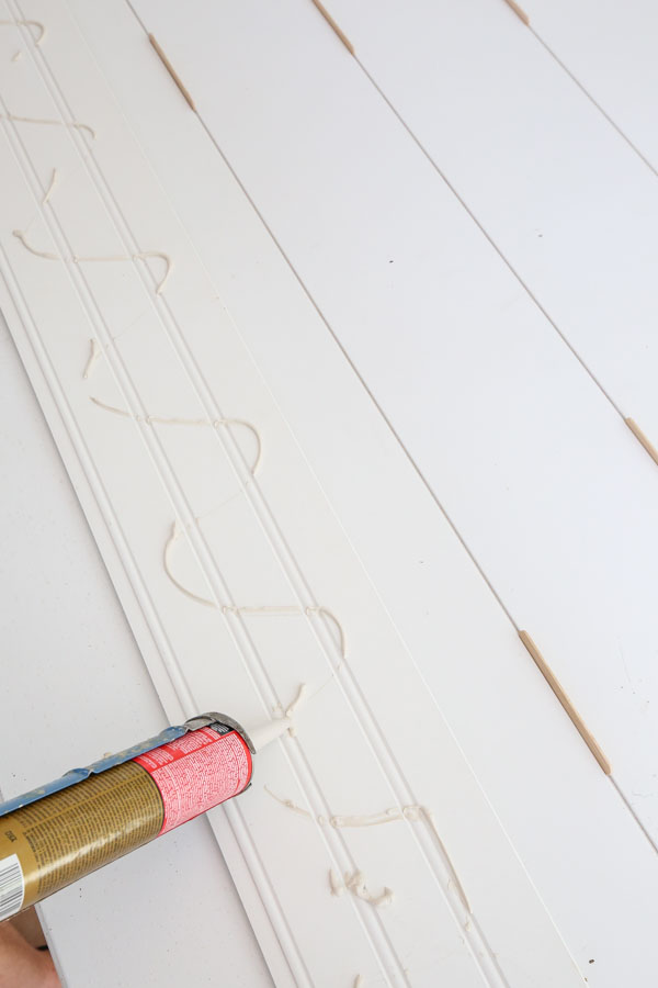 attaching shiplap boards to door with construction adhesive