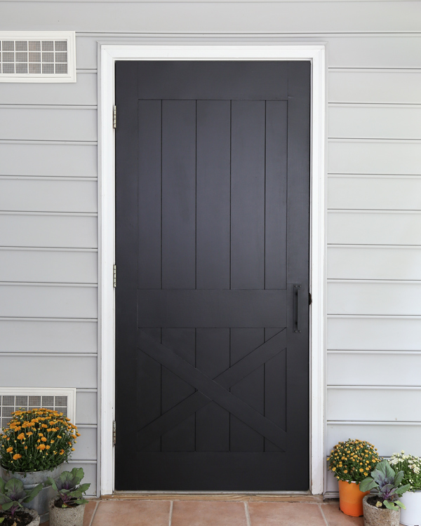 DIY faux barn door painted black on back porch