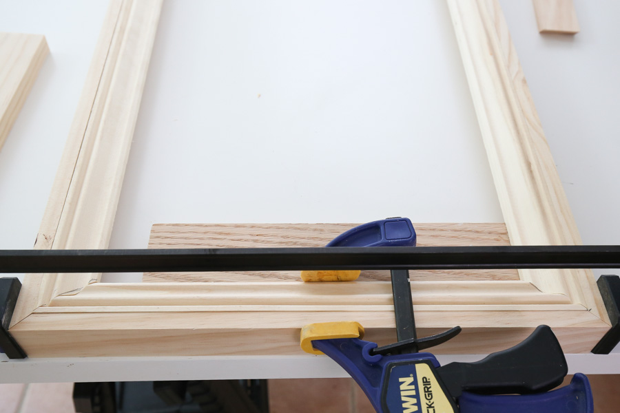 adding 1/2" thick wood to molding frame with clamps and brad nails