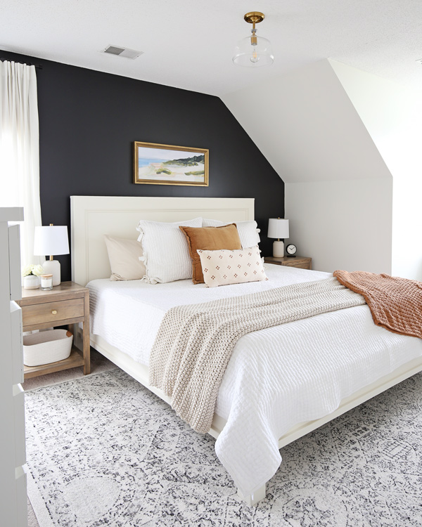 layer a rug under the bed for a cozy layered bedding look