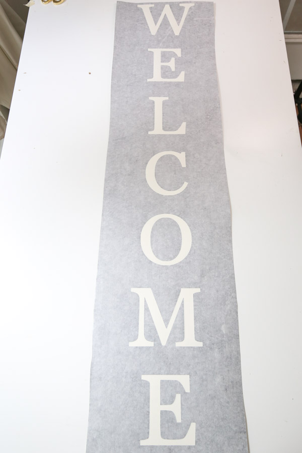 transfer tape applied to vinyl stencil for DIY welcome sign