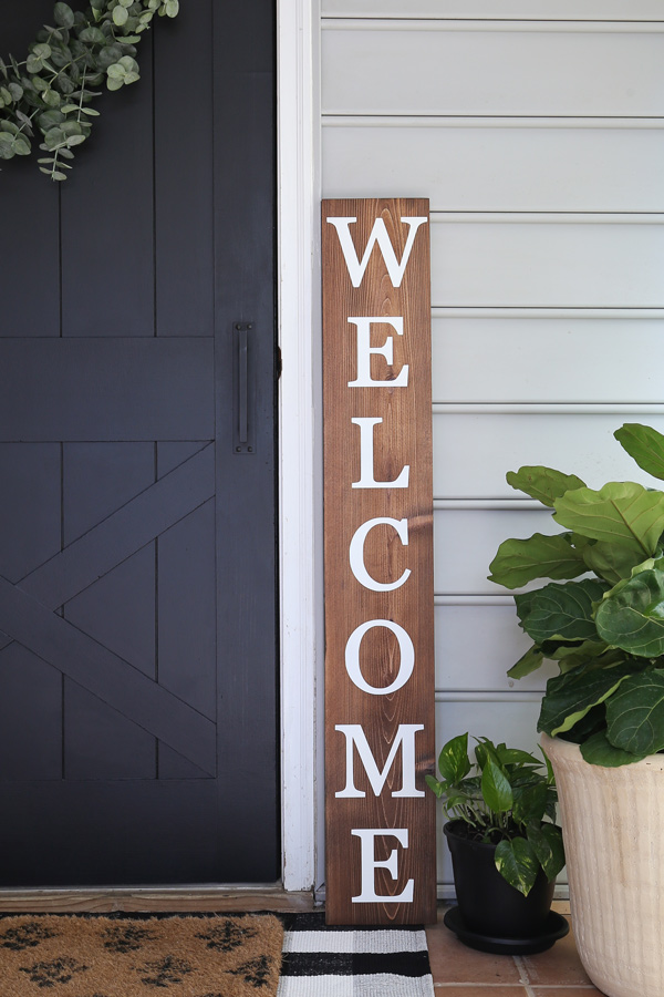 DIY welcome sign next to door and plants