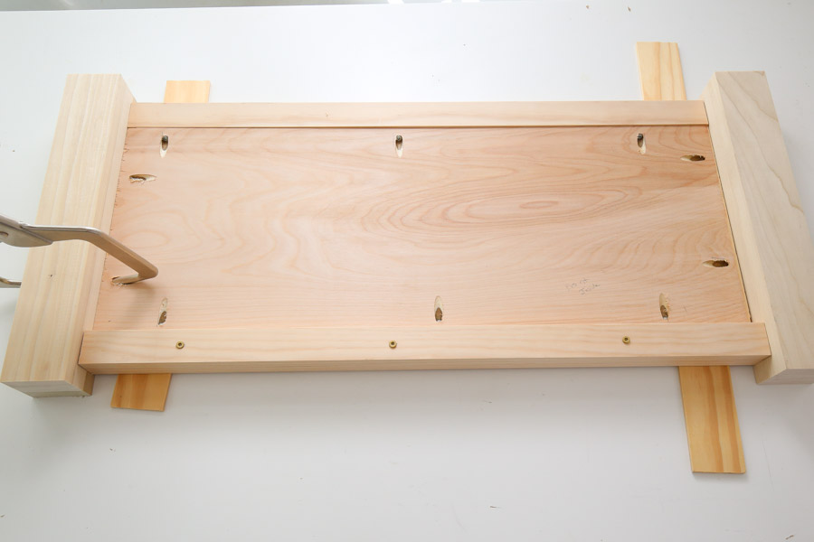 attach front side of diy toy box to legs with kreg screws, clamp, and wood glue