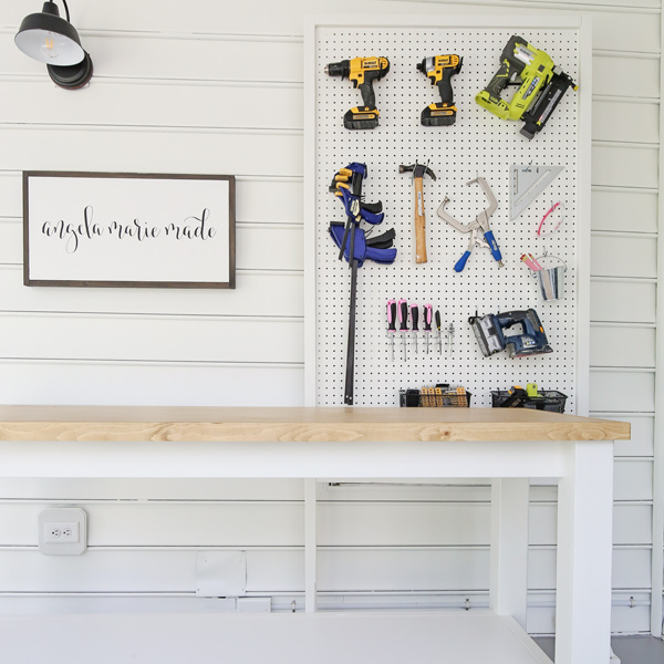 small workshop with DIY workbench and tool pegboard wall