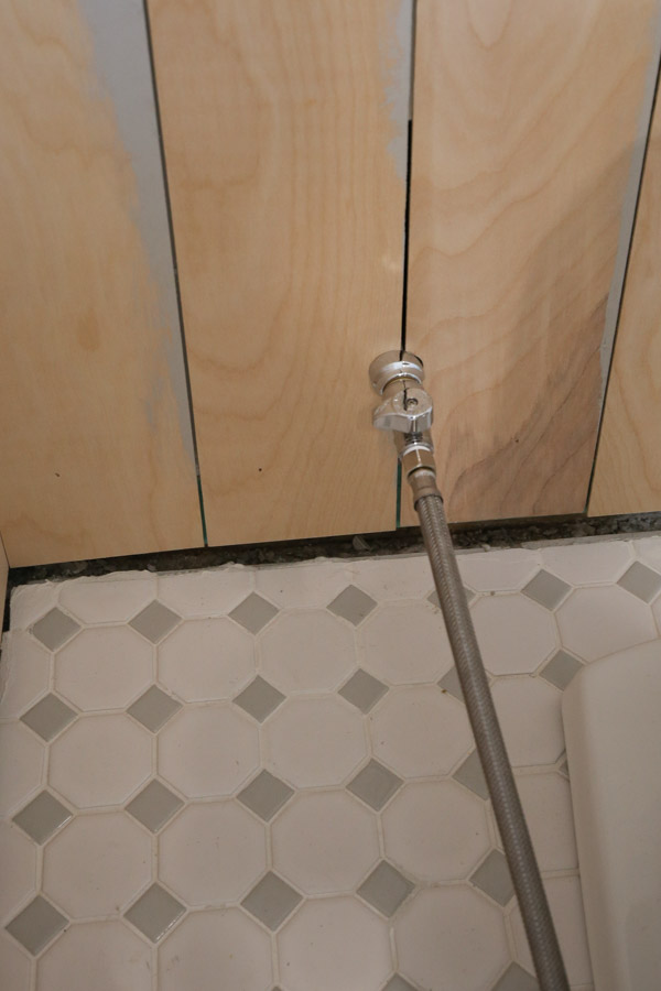 vertical shiplap bathroom installation and cutting around pipes